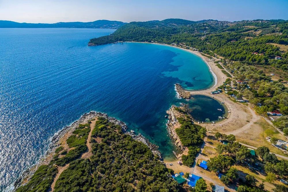 Aerial view of the curved sandy bay and turquoise water at Chrousso Beach near Paliouri.