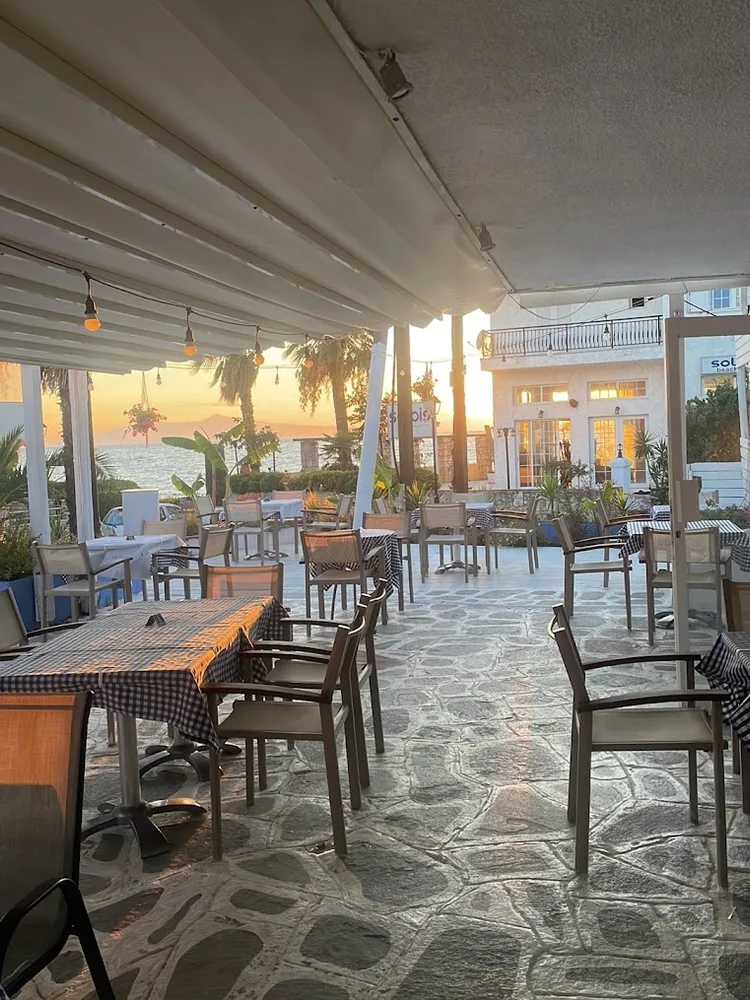 Tsiroko’s covered dining terrace, with tables overlooking the sea at sunset in Skala Fourka.